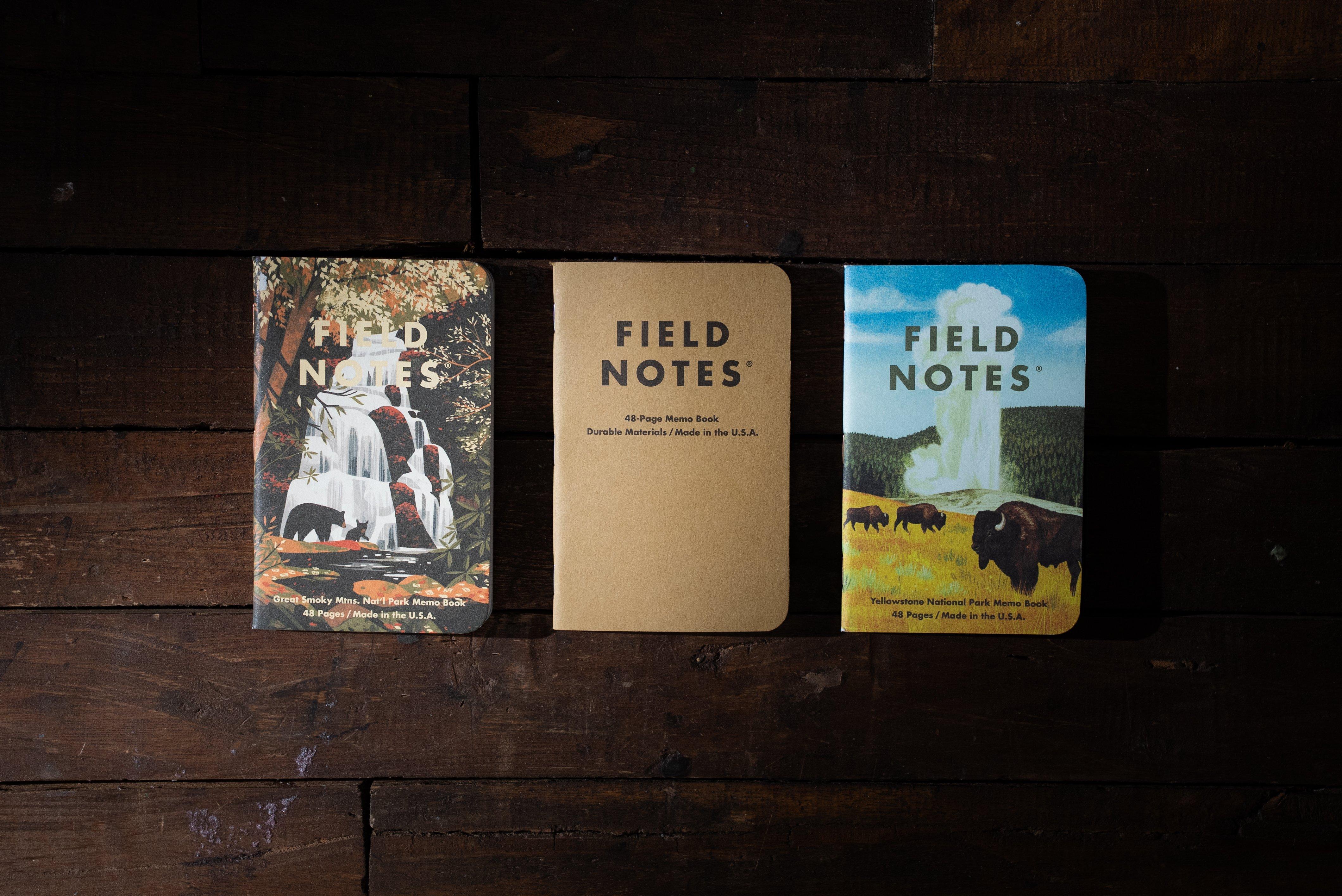 3 verschiedene Field Notes Notizbücher vor einem dunkelbraunen Holzhintergrund.