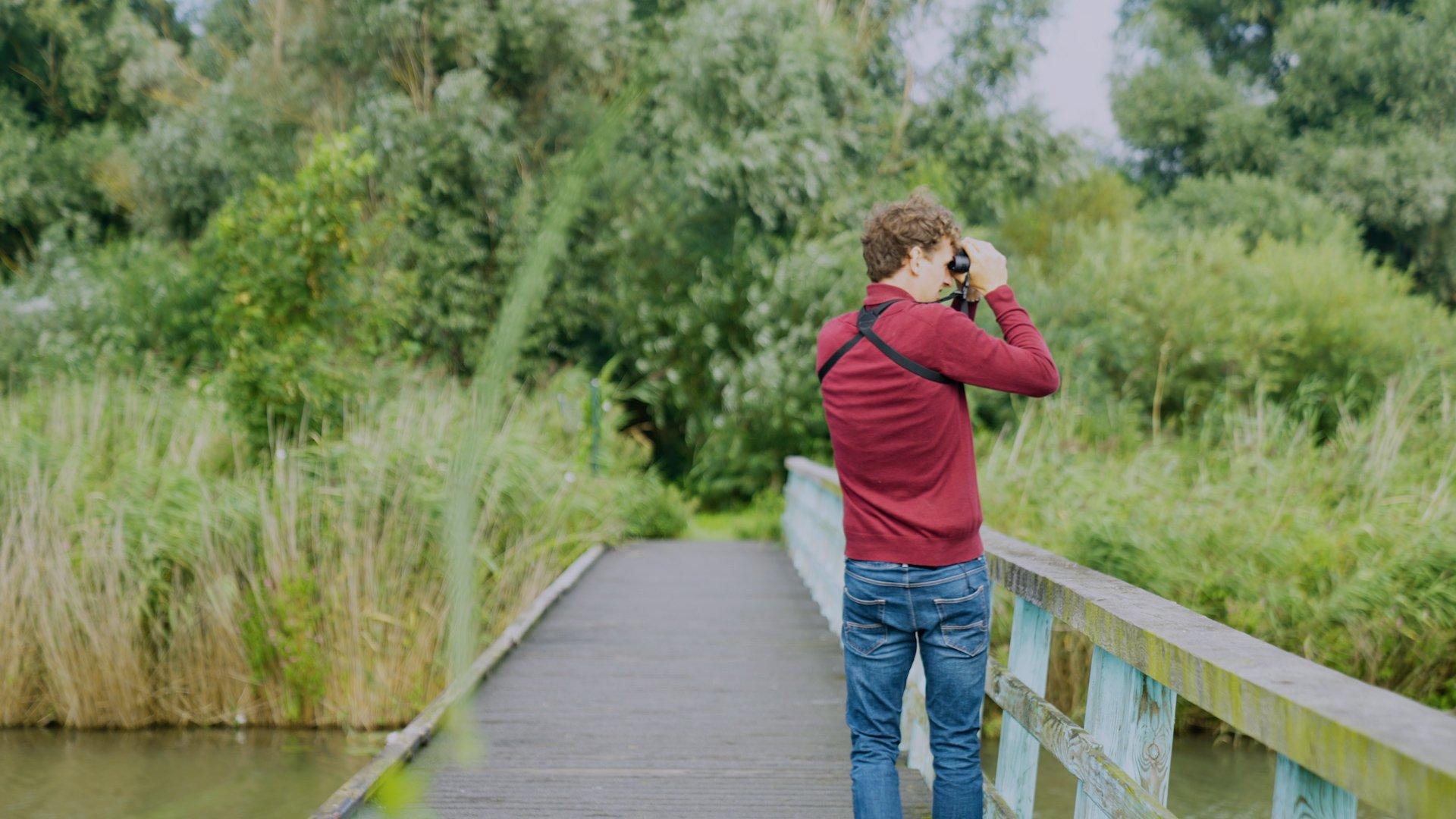 Ein Fernglas Experte schaut mit einem Fernglas in die Natur