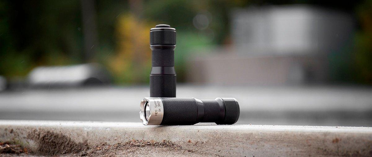 Two HDS Systems torches: one rests on the ground sideways, while the other is upright and the button is facing upwards
