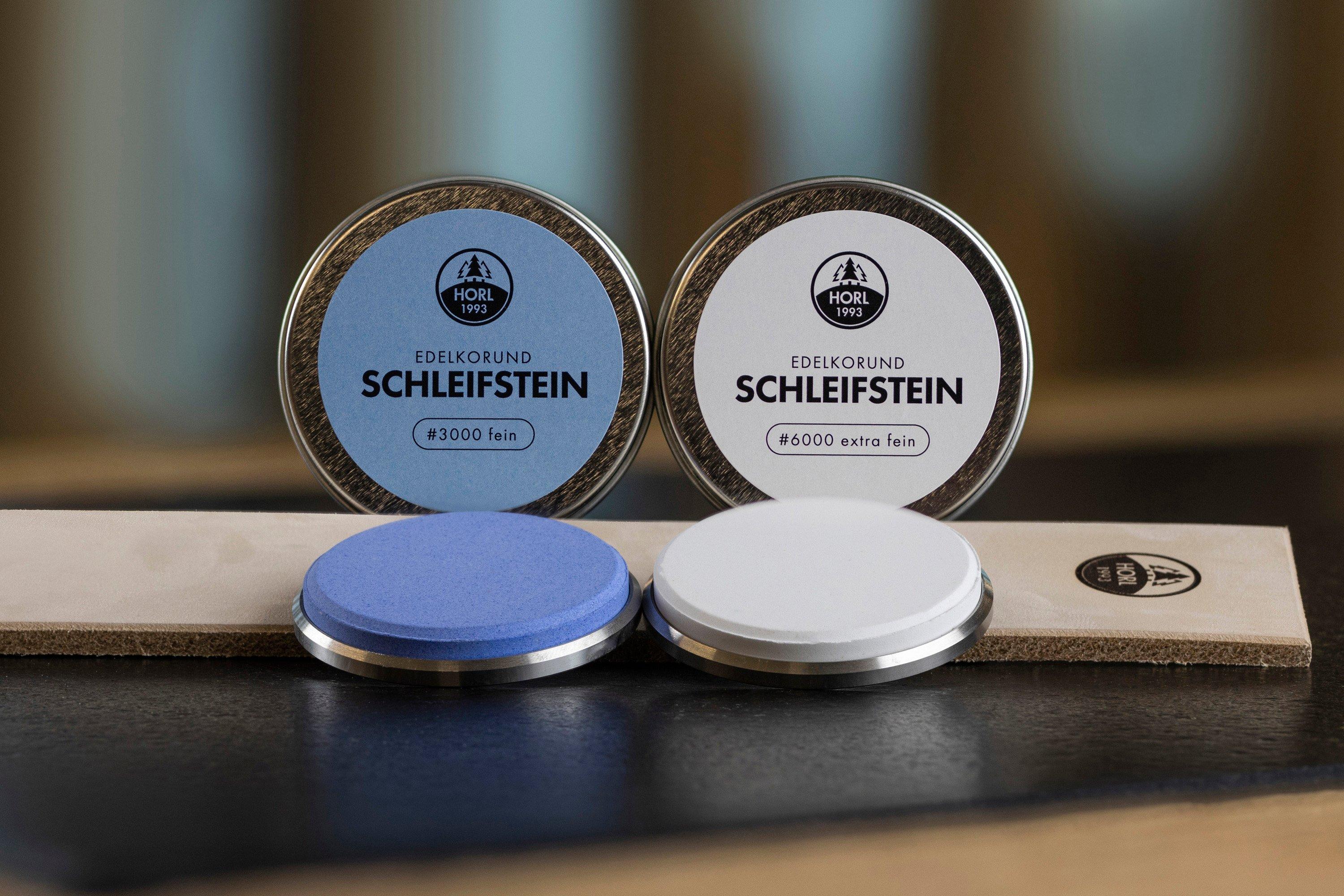 Un set de piedras de afilar, pasta de afilado y un asentador HORL en una mesa