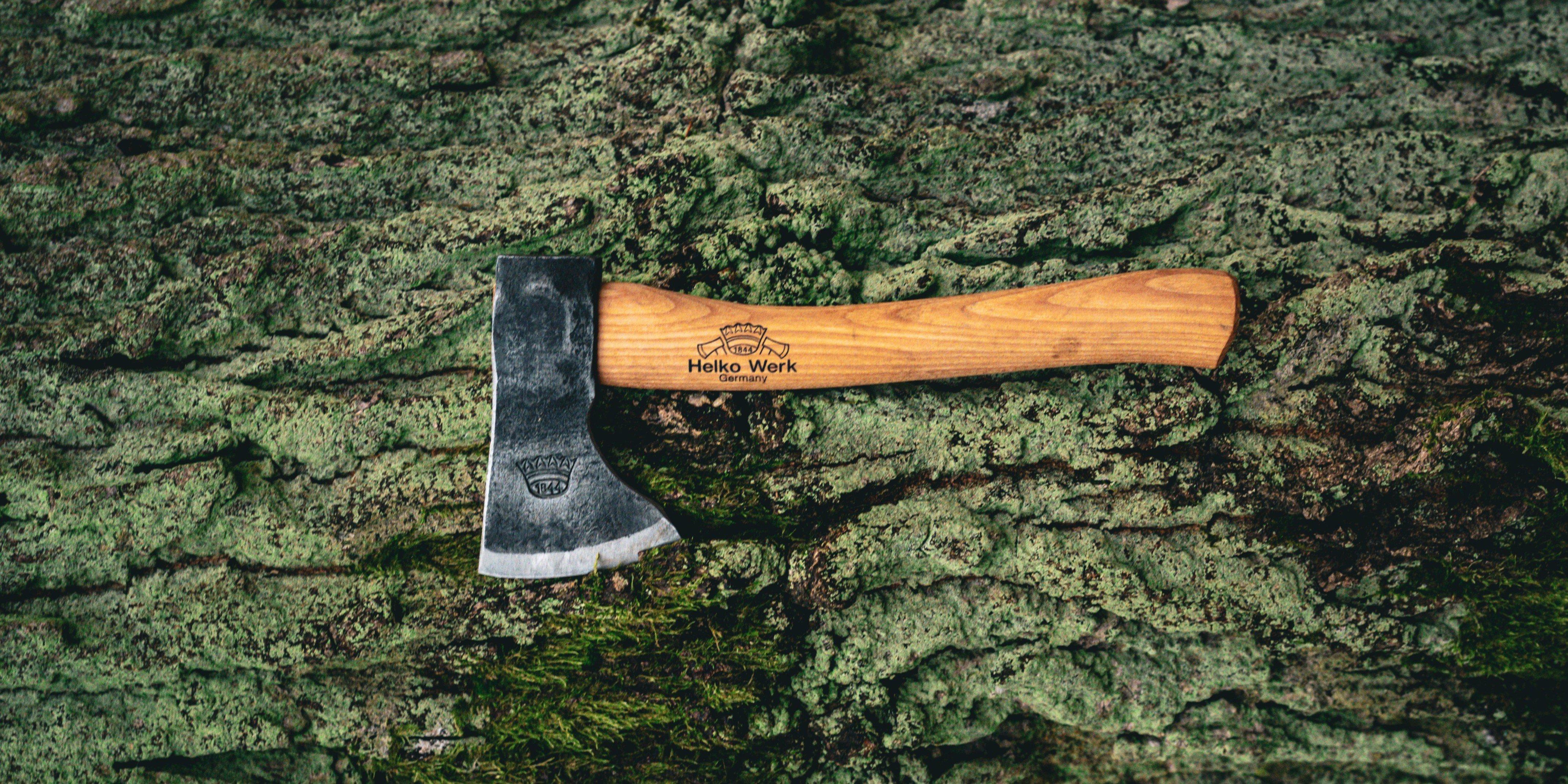 Helko Werk handbijl met houten steel op ruwe boomschors