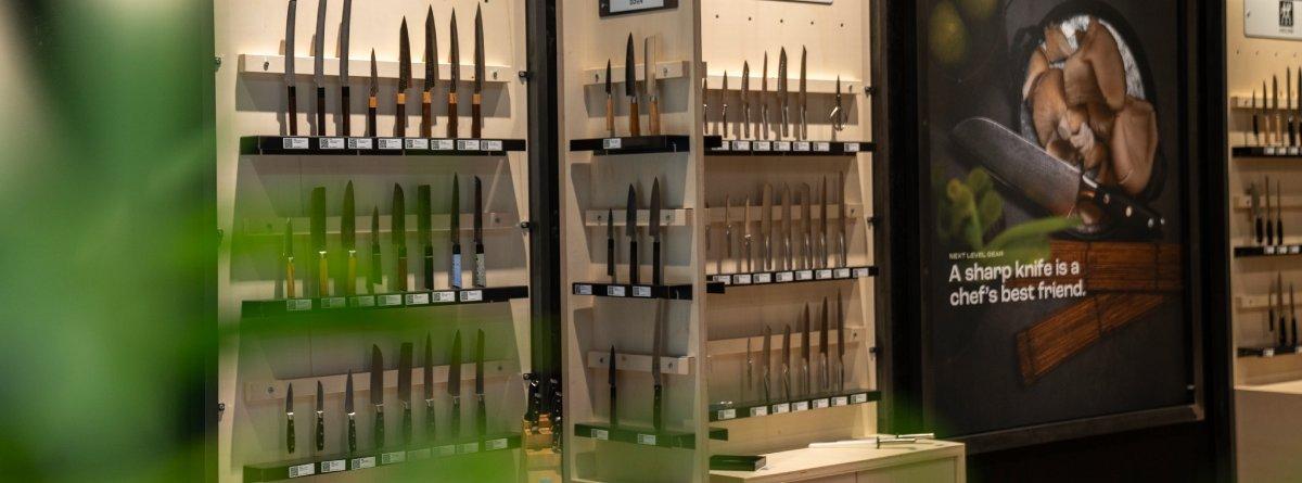 Kochmesser verschiedener Hersteller auf regalen im Knivesandtools Experience Center