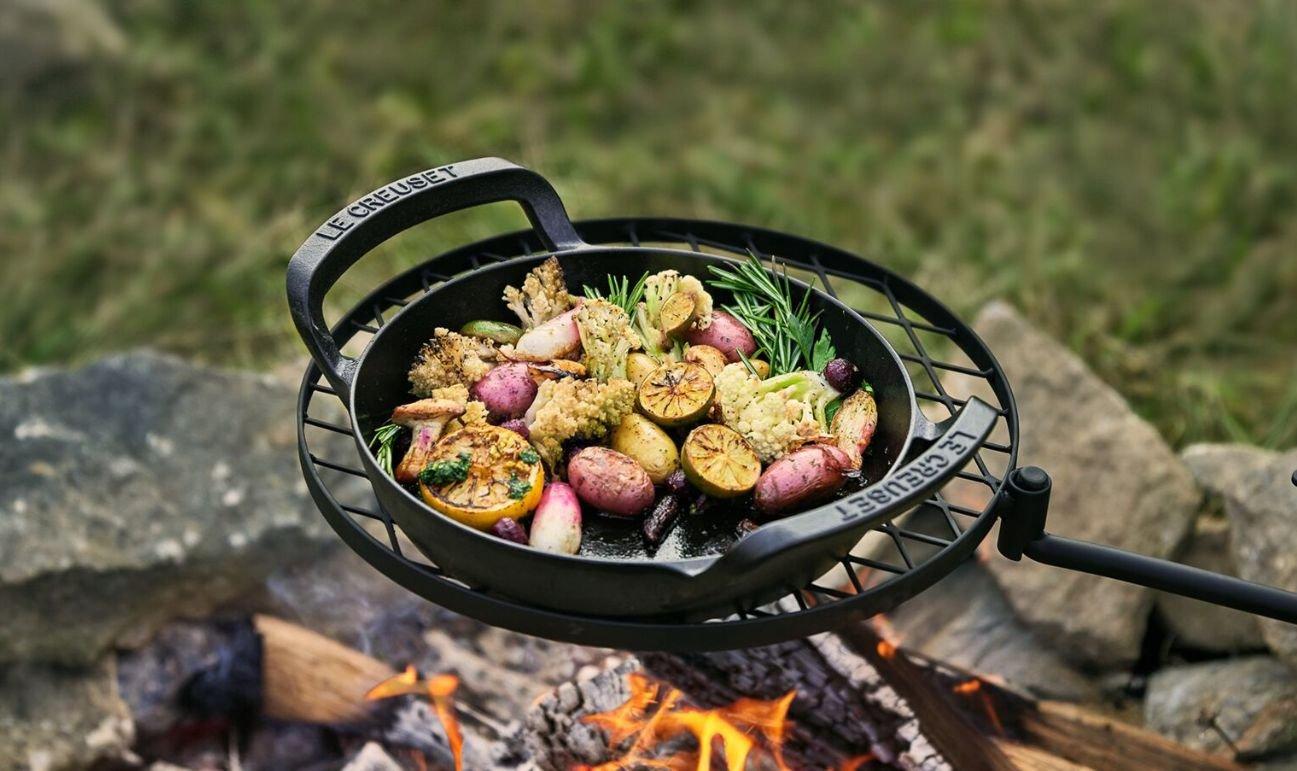 Persoon die buiten grilt met een Le Creuset BBQ Collection braadpan op de barbecue
