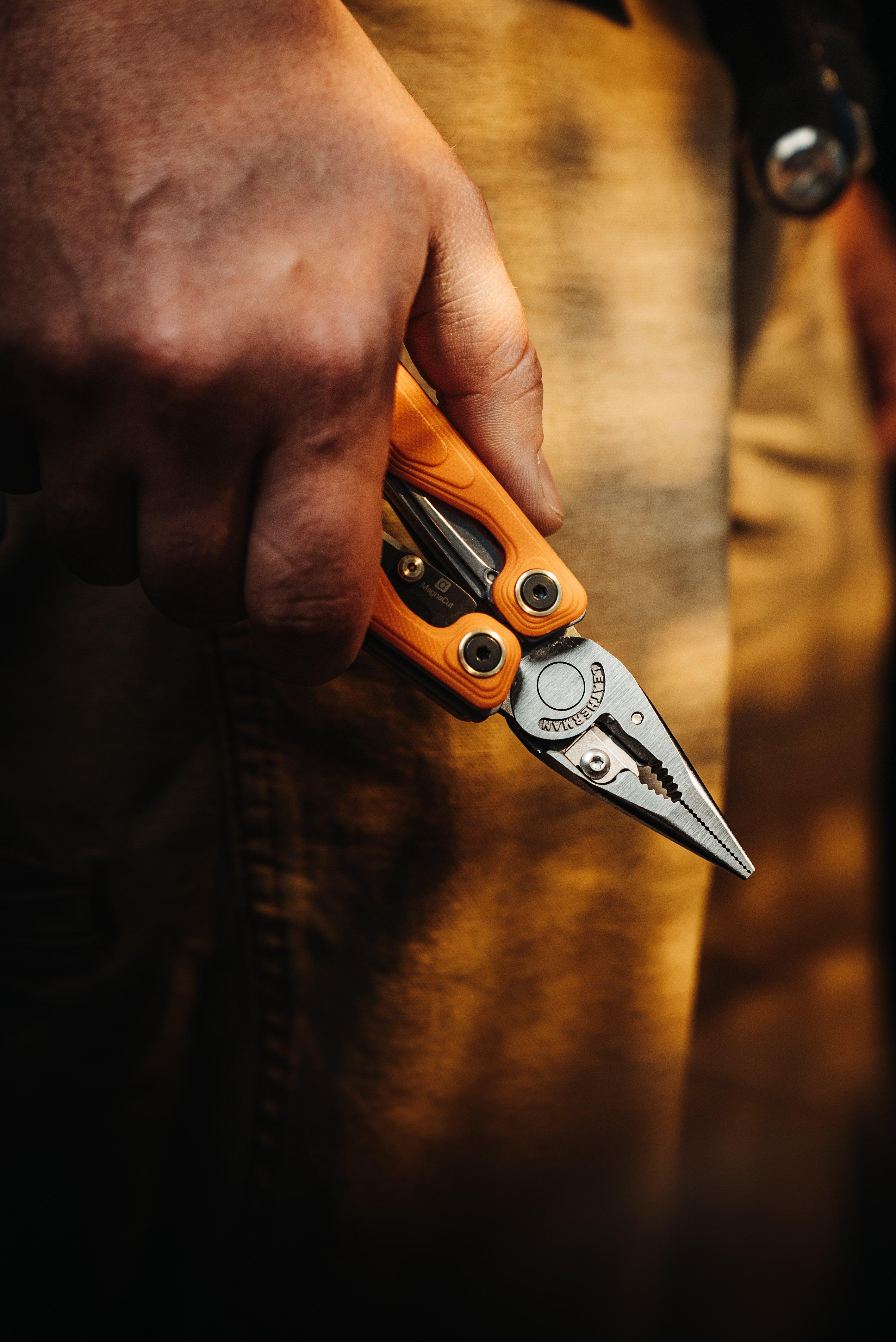 Hand mit einem orangefarbenen Leatherman Wave Alpha