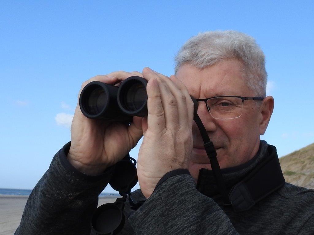 Paul Böhre met een Eden ED verrekijker aan het strand