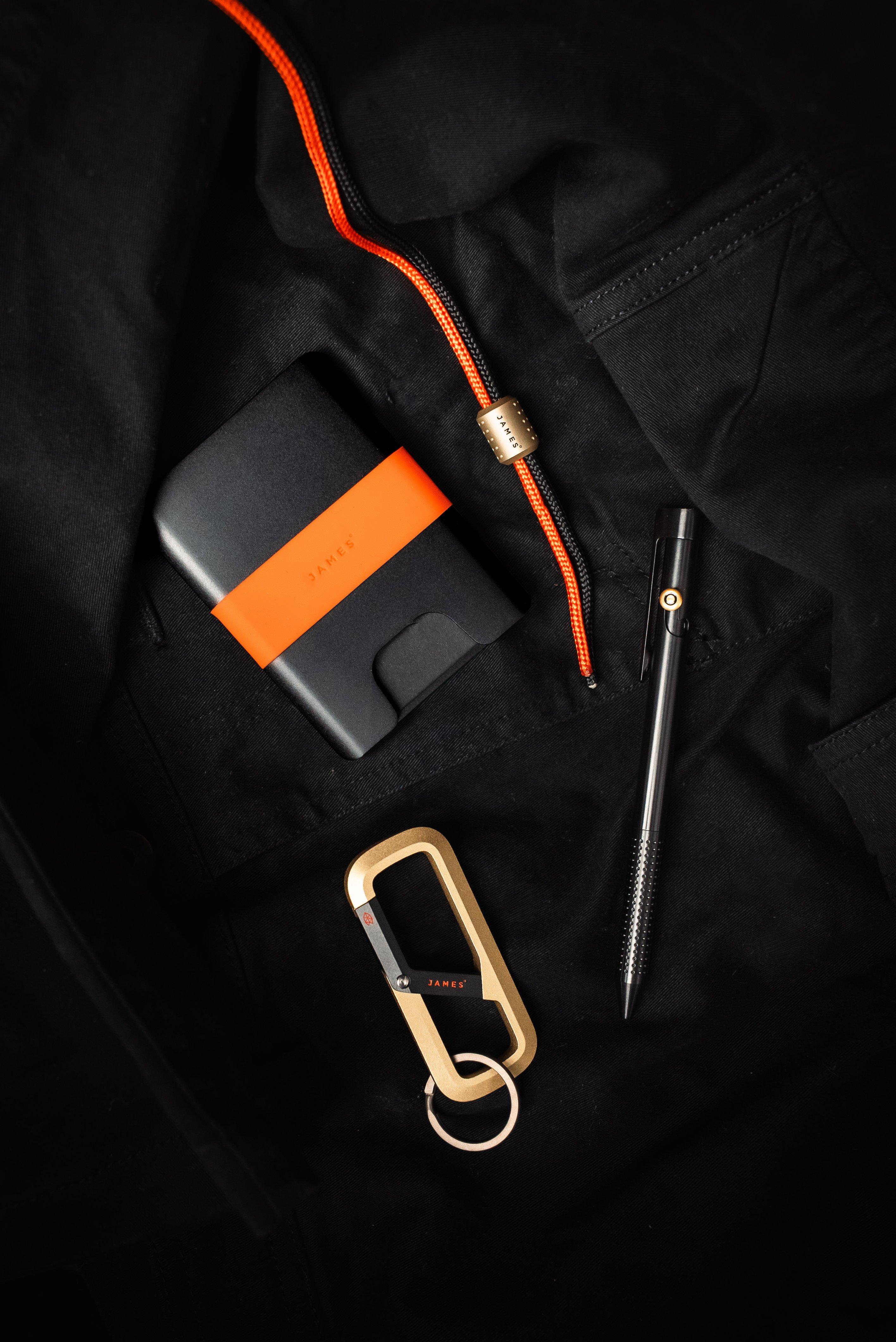 Varios productos de la colección Nocturne Collection de The James Brand en un suelo negro.