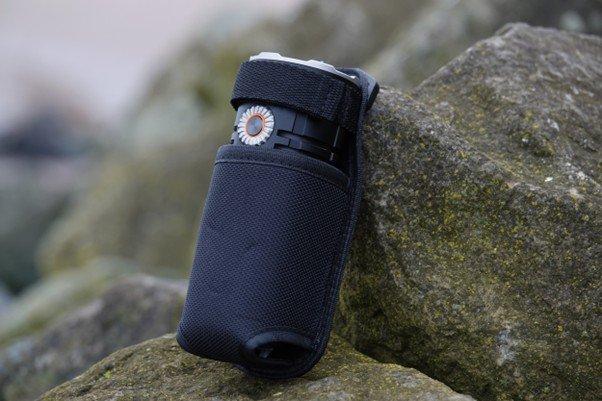 De Fenix LR35R Pro in zijn bijgeleverde holster, op een steen