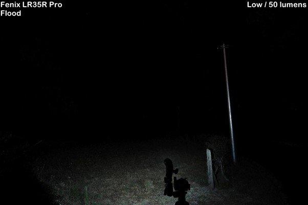 De Fenix LR35R Pro op de stand "Flood" low / 50 lumens in een donkere achtertuin gedemonstreerd