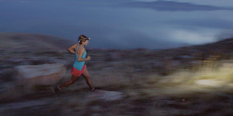 A woman running with a Petzl Tikka headtorch on