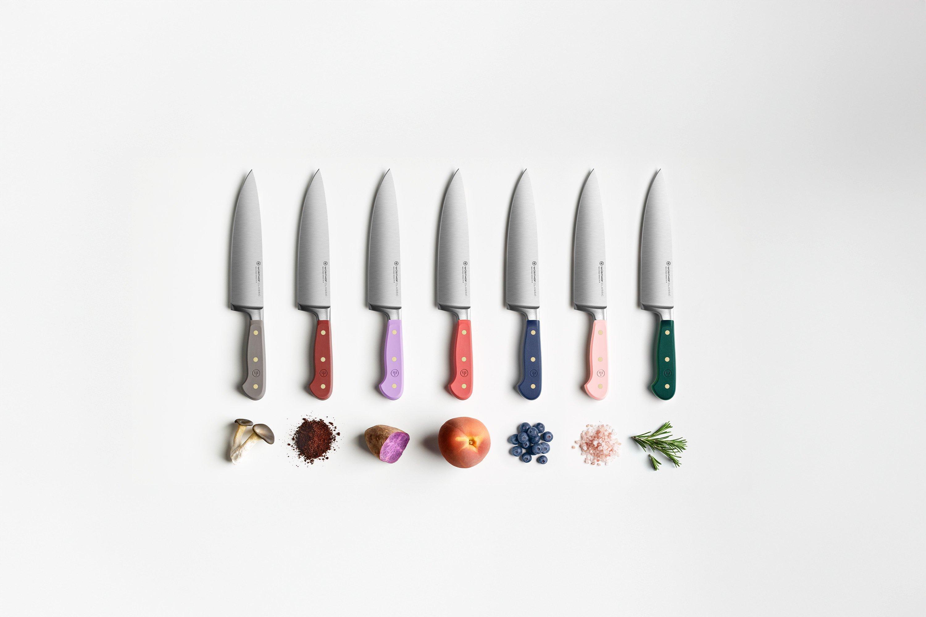 Wüsthof Classic Color Kochmesser in verschiedenen Farben, präsentiert auf einem rosafarbenen Hintergrund